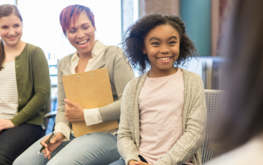 Girl smiling with woman looking on